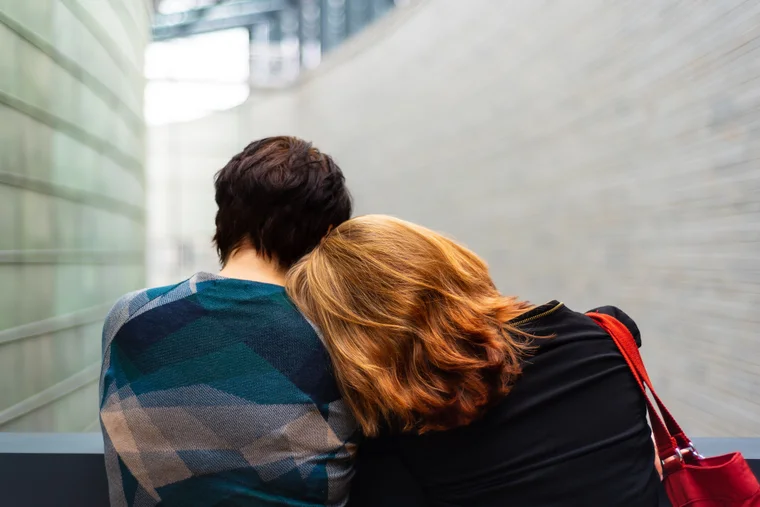 two women with one resting her head on the others shoulder
