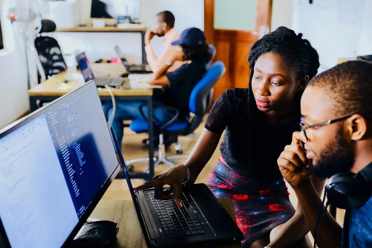 woman helping man on computer