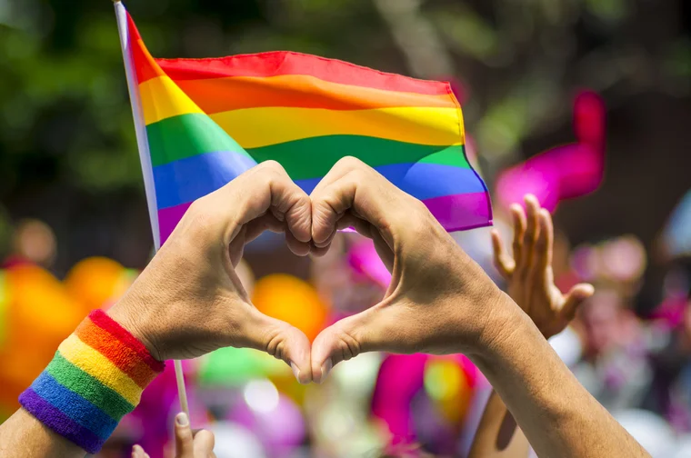 rainbow lgbtqia+ flag with heart hands in front